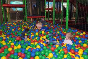 Peuters en kleuters die zich uitstekend vermaken in een kleurrijke ballenbak