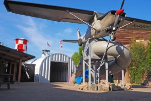 Prachtig oud vrachtvliegtuig bovenop een glijbaan, vlak voor de hangar waar je doorheen loopt naar de rest van Dinoland.