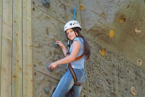 Meisje heeft veel plezier aan de klimwand bij Dinoland.