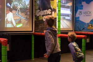 2 kinderen die zich vermaken in de speelhal met videospellen op onder meer de xBox. 